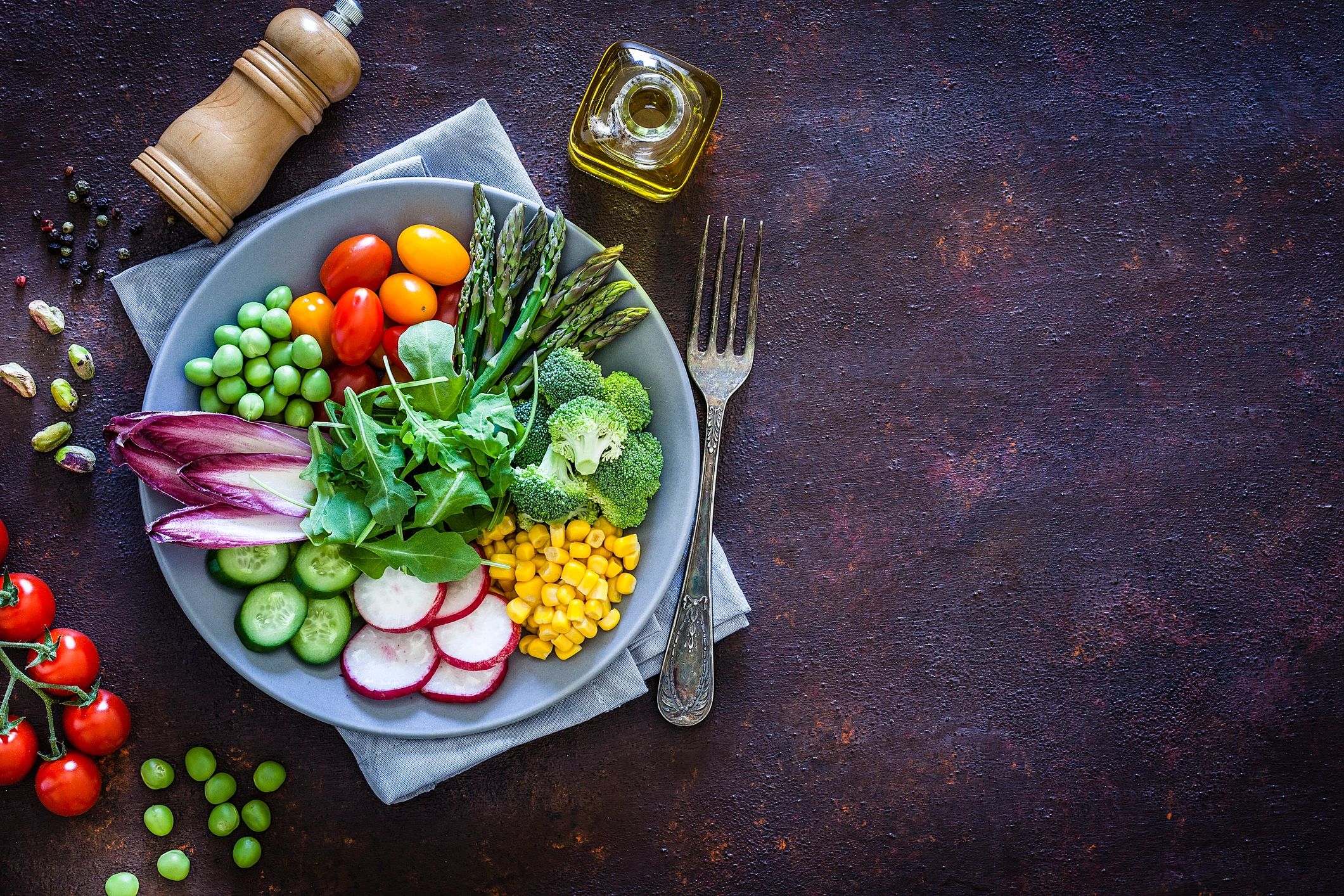 Fresh green salad ingredients arranged on a rustic table