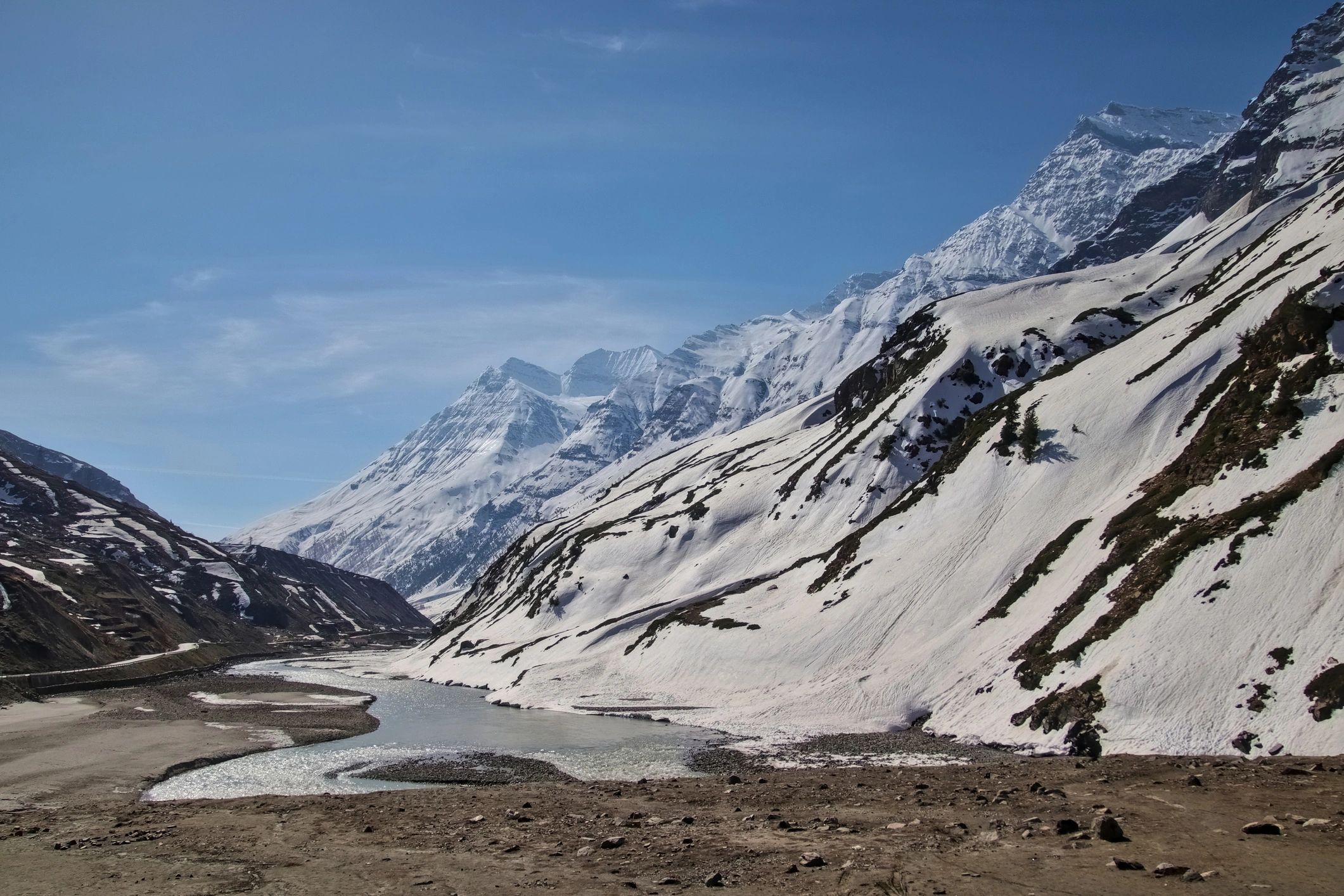 Mountain river flowing through a snowy Himalayan valley