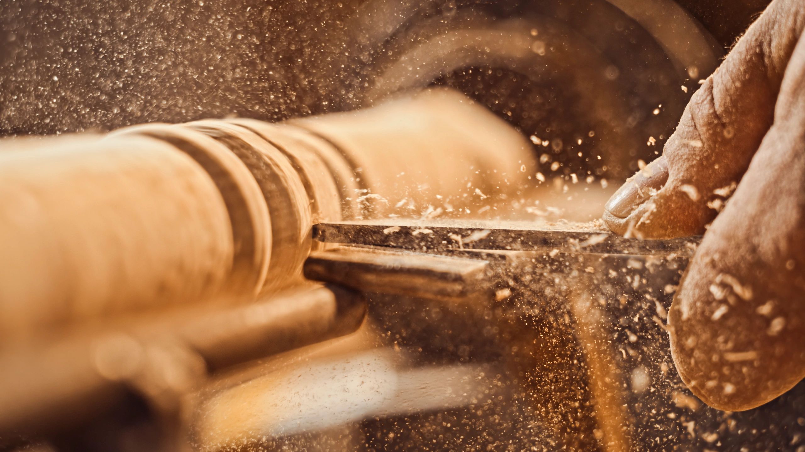 Close-up of a hand working on wood with tools