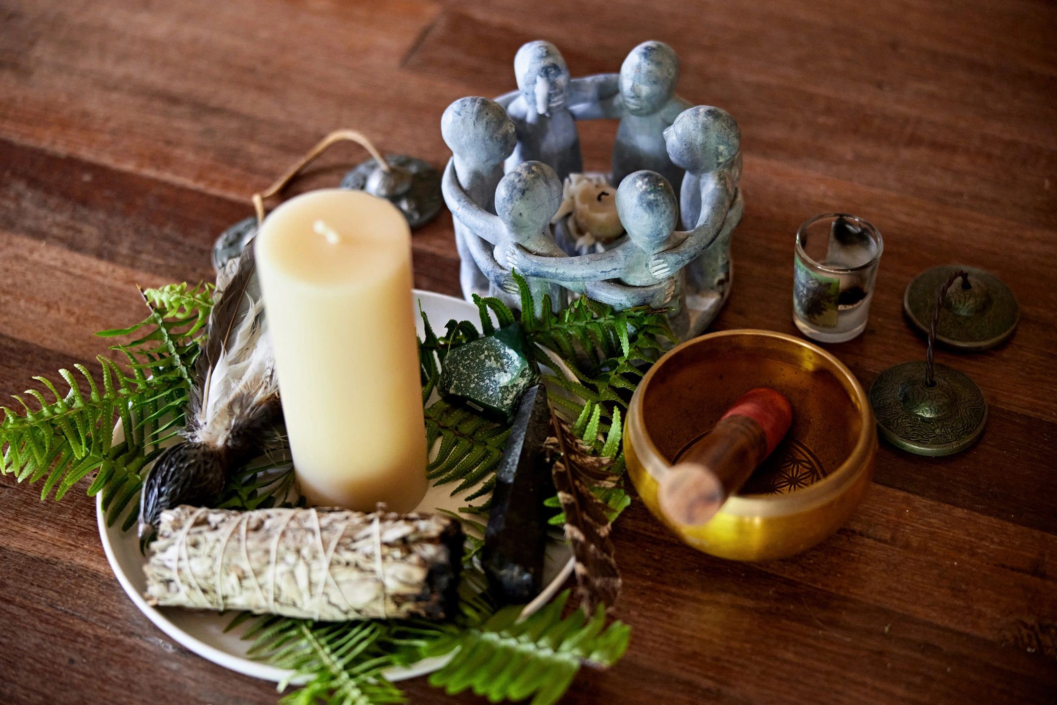 Candles and singing bowl arranged on a wooden floor for meditation