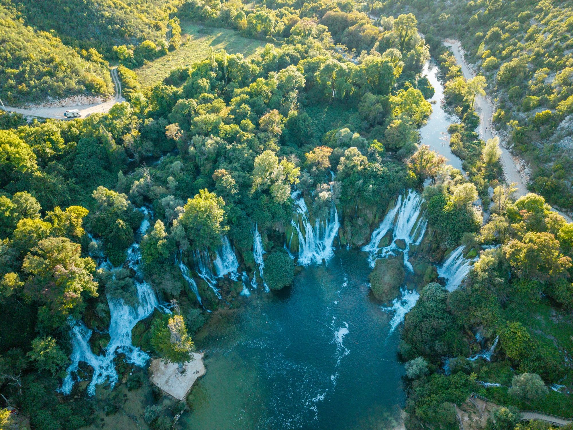 Waterfalls cascading into a forest river