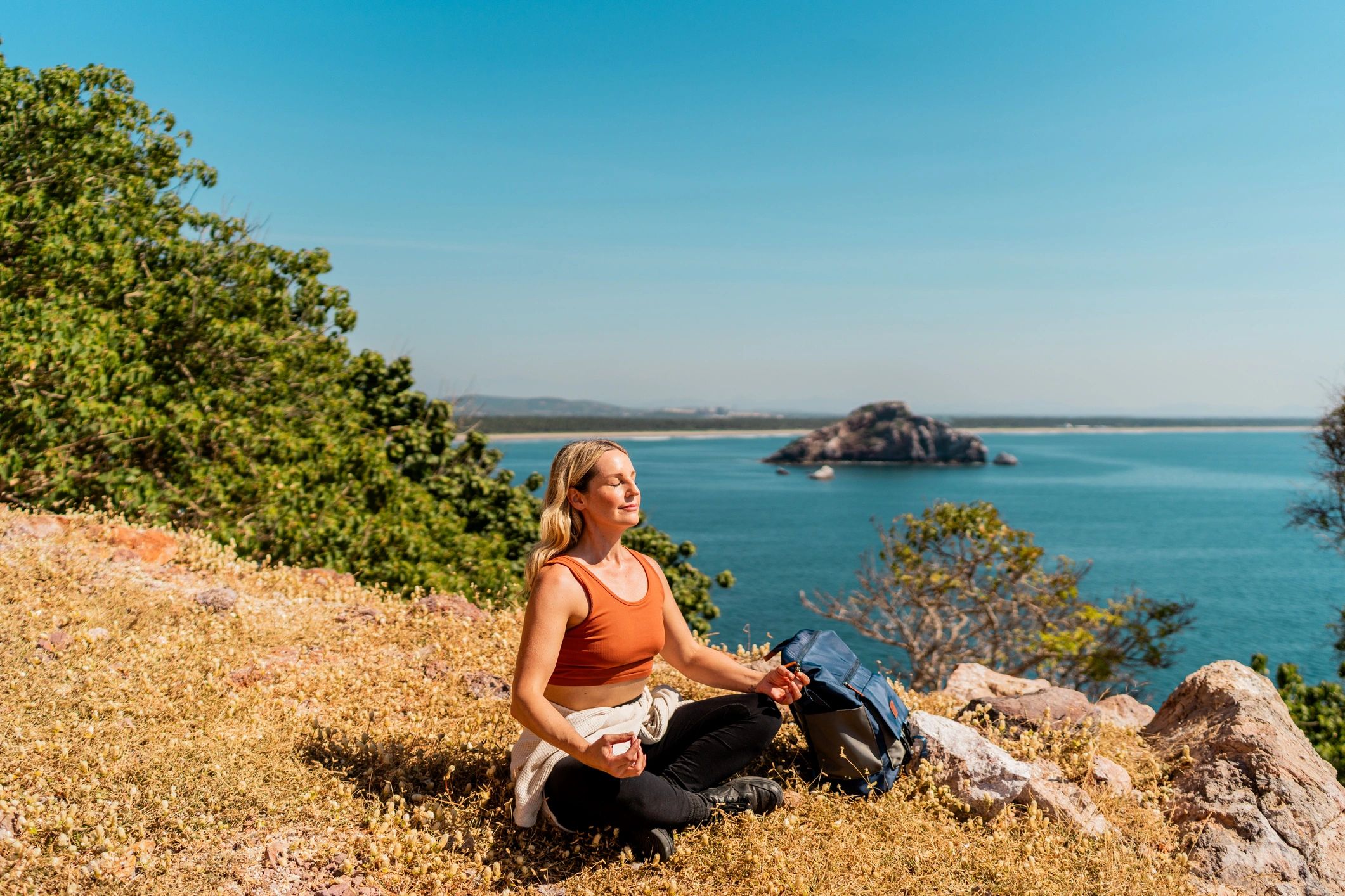 Person meditating outdoors with mountain views