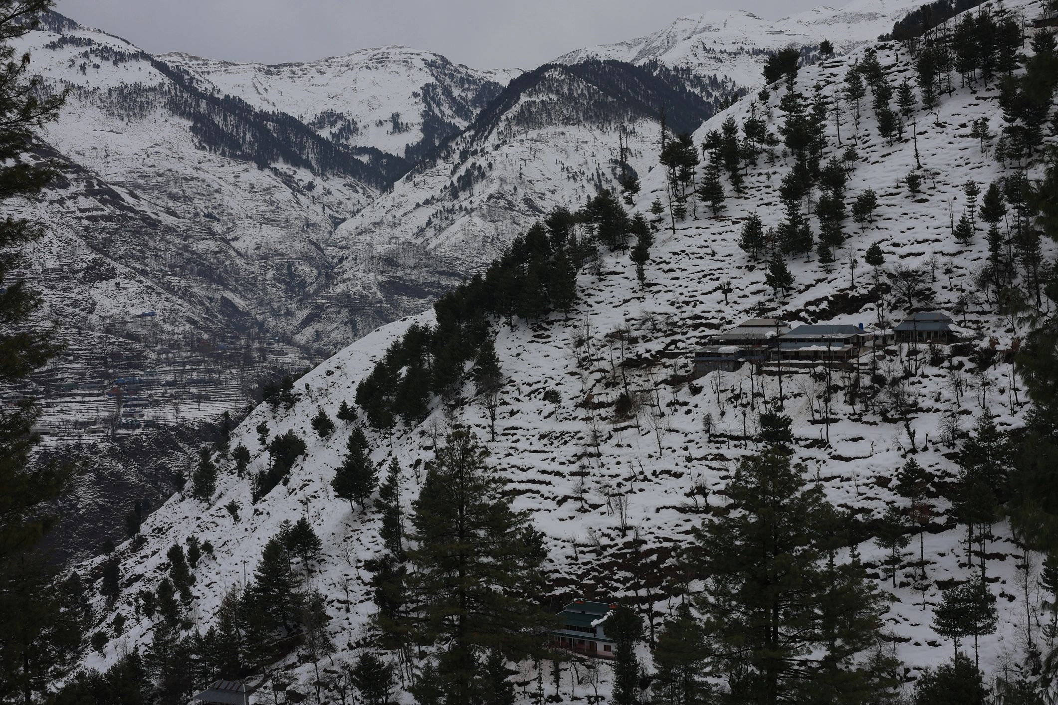 Snow-capped Himalayan peaks above a quiet mountain settlement