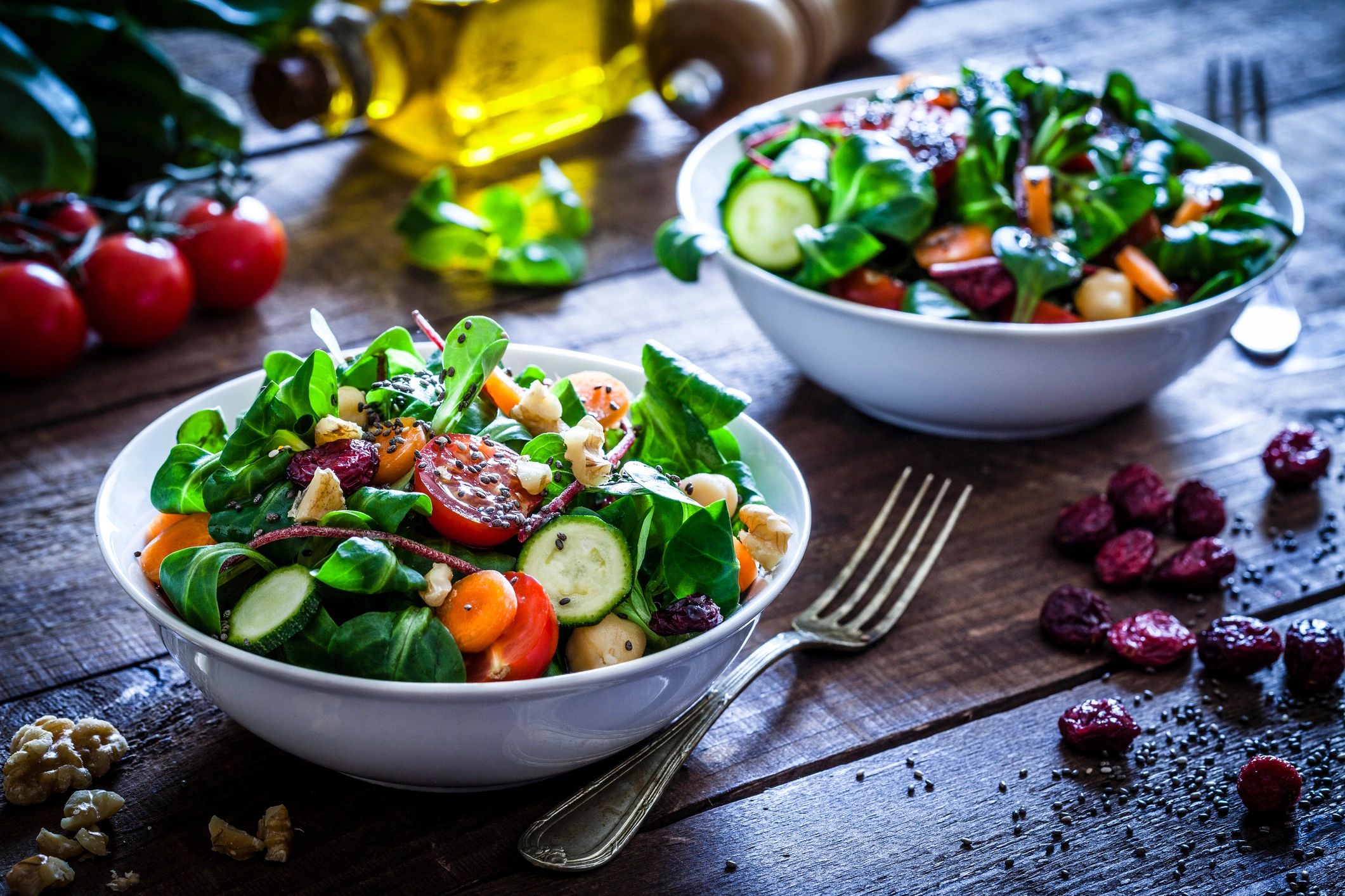 Two healthy salad bowls on a wooden table